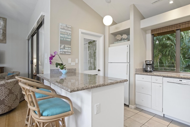 3300 Wailea Alanui Dr Unit 52D, Kihei, HI 96753 - kitchen featuring white appliances, a breakfast bar area, white cabinetry, a peninsula, and light stone countertops