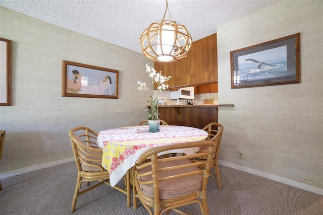 dining space with baseboards, carpet, and a textured ceiling