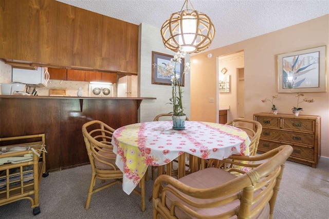 carpeted dining area featuring a textured ceiling