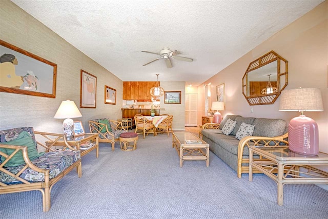 carpeted living room featuring a ceiling fan and a textured ceiling