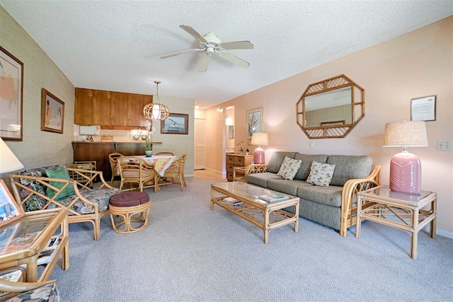 living area featuring a ceiling fan, carpet floors, and a textured ceiling