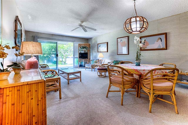 dining space with a textured ceiling, ceiling fan, and carpet flooring