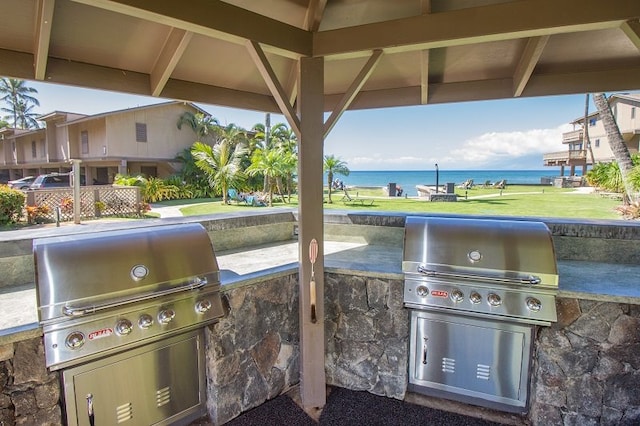 view of patio / terrace with area for grilling, grilling area, and a water view