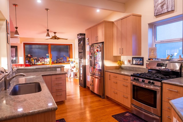 kitchen with stainless steel appliances, decorative light fixtures, ceiling fan, light wood-type flooring, and sink