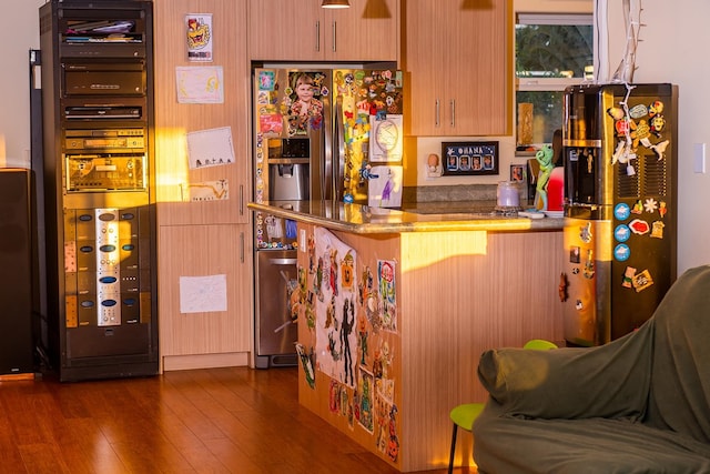 bar featuring stainless steel fridge with ice dispenser and dark hardwood / wood-style floors