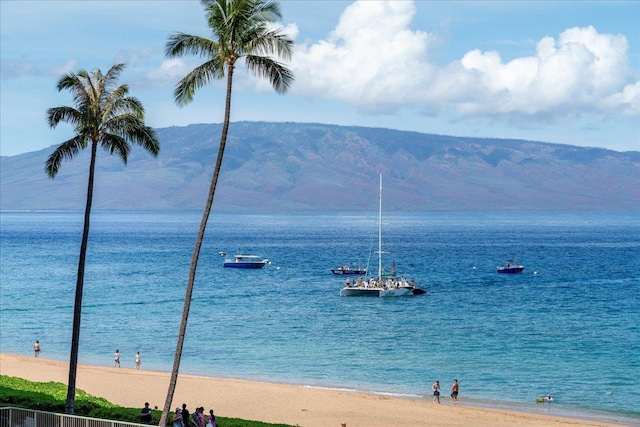 view of water feature with a beach view and a mountain view