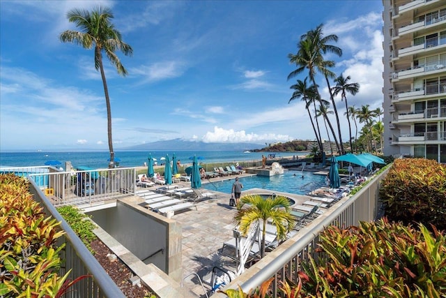 pool with a patio and a water view