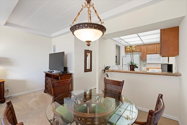 dining space featuring baseboards and light colored carpet