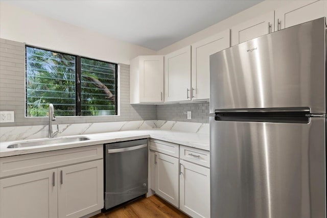 kitchen with white cabinets, sink, appliances with stainless steel finishes, dark hardwood / wood-style floors, and light stone countertops