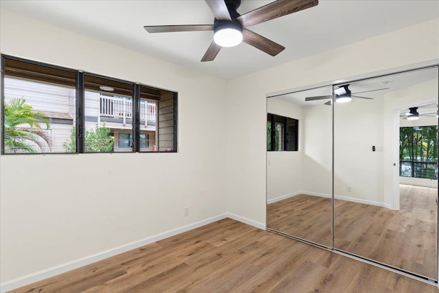 unfurnished bedroom with ceiling fan, a closet, and multiple windows