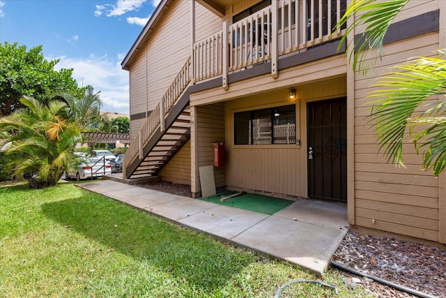 doorway to property featuring a balcony and a lawn