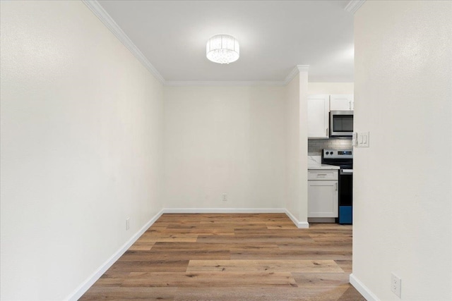 interior space with light wood-type flooring, appliances with stainless steel finishes, backsplash, and white cabinetry