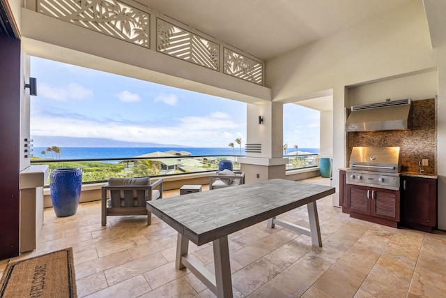 view of patio with exterior kitchen, a water and mountain view, and a grill