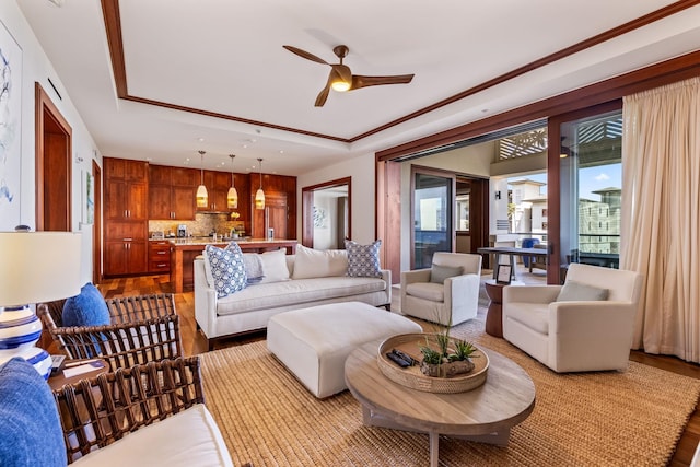 living room featuring ceiling fan, light hardwood / wood-style flooring, and a raised ceiling