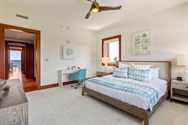 bedroom with ceiling fan, light carpet, and multiple windows