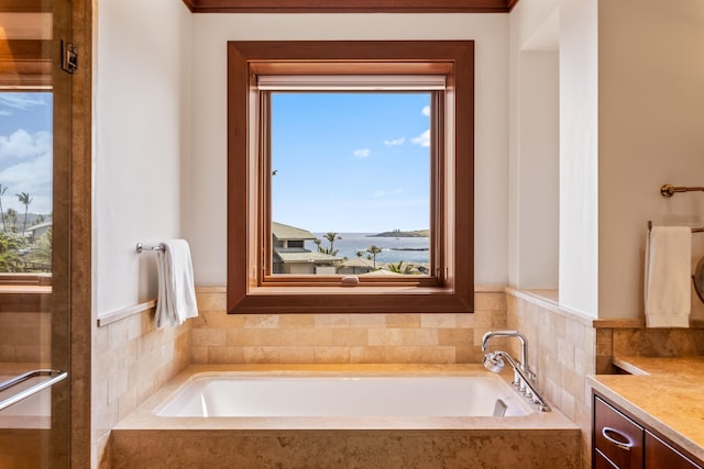 bathroom featuring vanity, tiled bath, and plenty of natural light