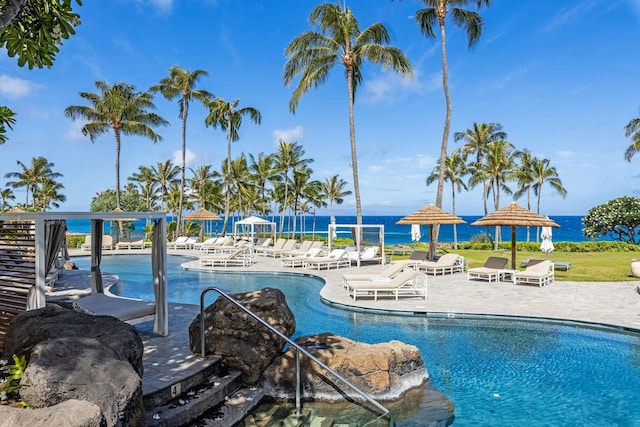 view of pool featuring a water view and a patio area