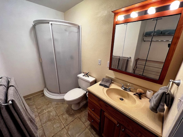 bathroom with tile patterned flooring, vanity, toilet, and a shower with shower door