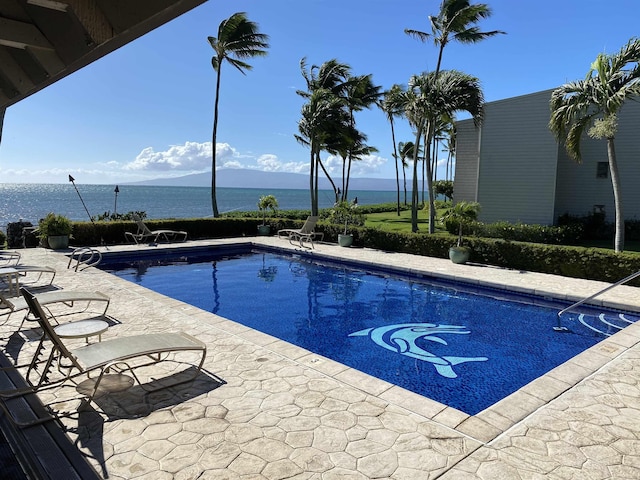 view of pool featuring a water view and a patio