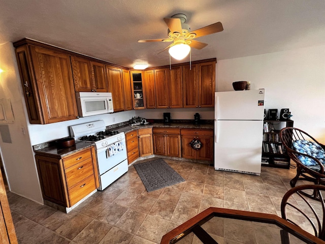 kitchen featuring a textured ceiling, white appliances, and ceiling fan