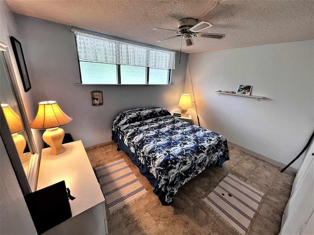 bedroom with a textured ceiling and ceiling fan