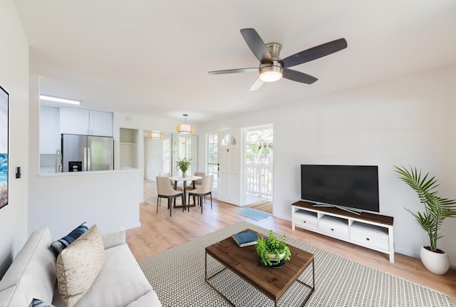 living room featuring ceiling fan and light hardwood / wood-style flooring