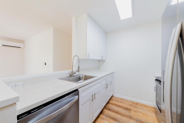 kitchen featuring white cabinets, sink, light hardwood / wood-style floors, stainless steel appliances, and a wall unit AC