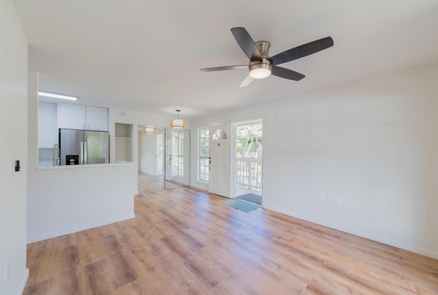 spare room with ceiling fan, french doors, and light wood-type flooring