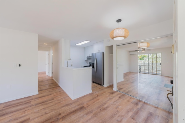 kitchen with white cabinetry, ceiling fan, sink, light hardwood / wood-style flooring, and stainless steel refrigerator with ice dispenser