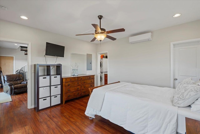 bedroom with a wall mounted air conditioner, dark wood finished floors, recessed lighting, and stacked washing maching and dryer