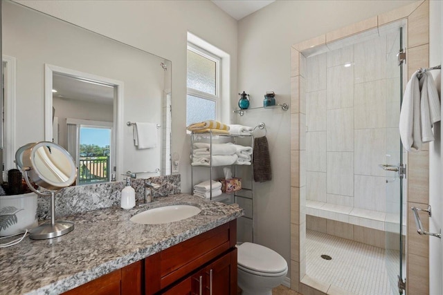 bathroom with toilet, a stall shower, and vanity