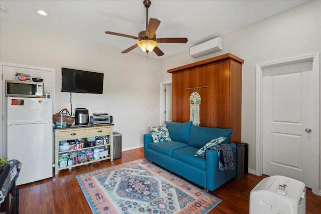 living room with baseboards, an AC wall unit, a ceiling fan, and wood finished floors