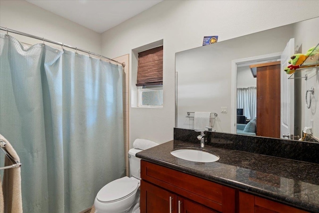 ensuite bathroom with vanity, curtained shower, toilet, and ensuite bathroom