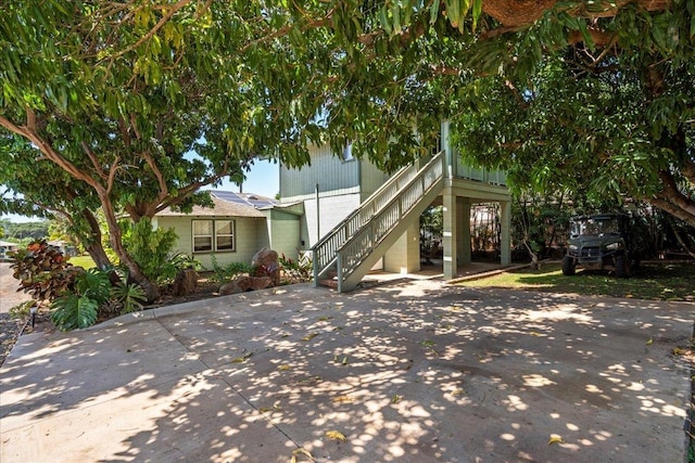 view of front of property with stairs, concrete driveway, and brick siding