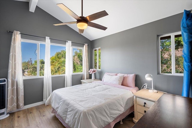 bedroom featuring multiple windows, lofted ceiling, baseboards, and light wood finished floors