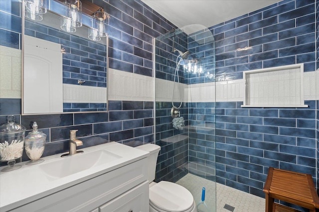 full bathroom featuring toilet, tile walls, vanity, and a walk in shower