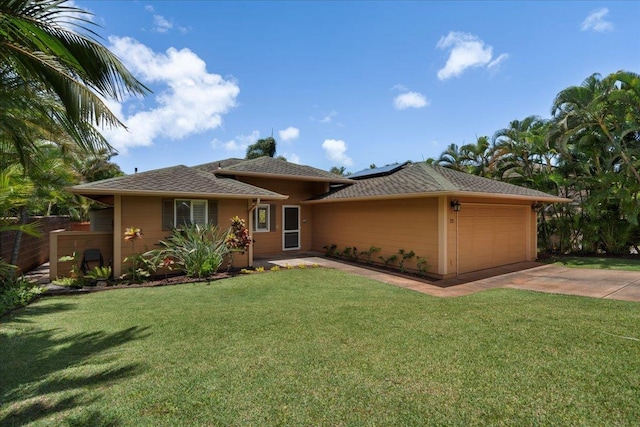 23 Poinciana Rd, Lahaina, HI 96761 - view of front facade with a garage, roof mounted solar panels, driveway, and a front yard