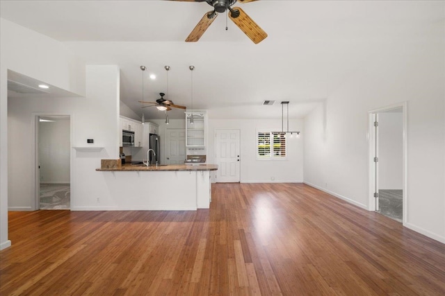 23 Poinciana Rd, Lahaina, HI 96761 - kitchen featuring a ceiling fan, stainless steel microwave, white cabinets, a peninsula, and vaulted ceiling