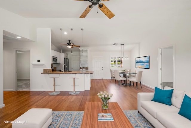 23 Poinciana Rd, Lahaina, HI 96761 - living area featuring ceiling fan, light wood-type flooring, vaulted ceiling, and baseboards