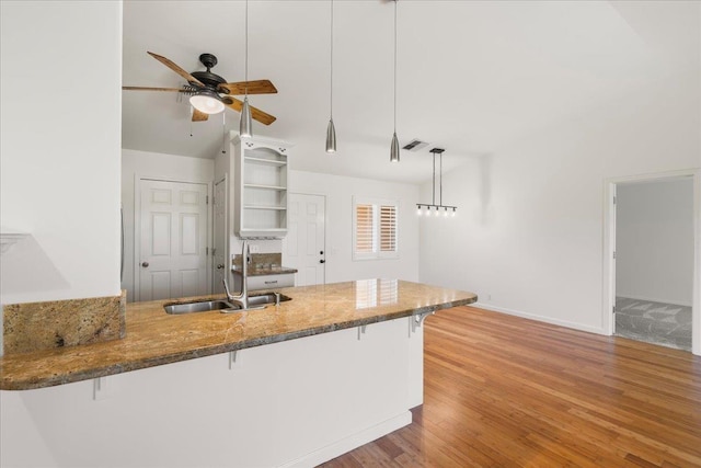 23 Poinciana Rd, Lahaina, HI 96761 - kitchen with a sink, a peninsula, a ceiling fan, a breakfast bar, and wood finished floors