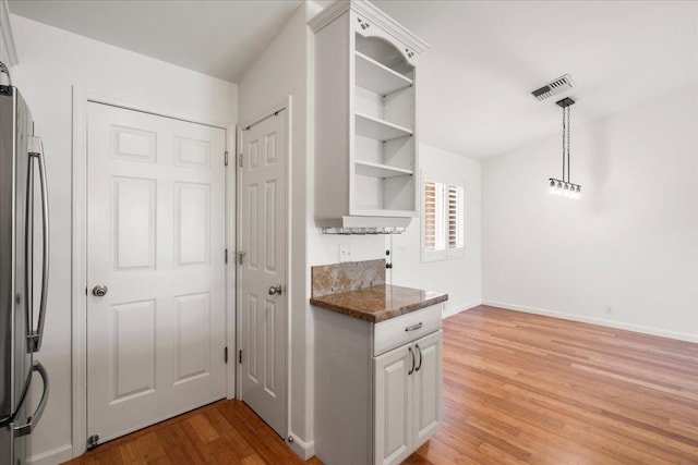 23 Poinciana Rd, Lahaina, HI 96761 - kitchen featuring freestanding refrigerator, open shelves, light wood-style floors, baseboards, and dark stone counters