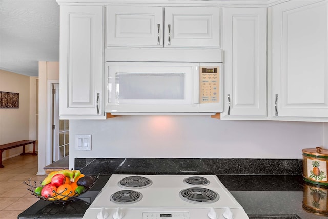 kitchen with tile patterned flooring, white cabinetry, and range with electric cooktop