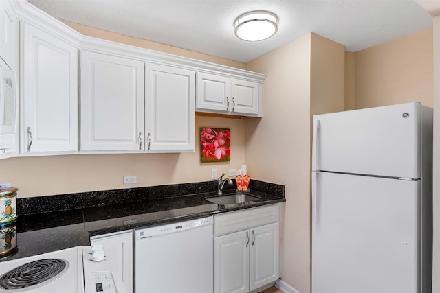 kitchen with sink, dark stone countertops, white cabinets, and white appliances