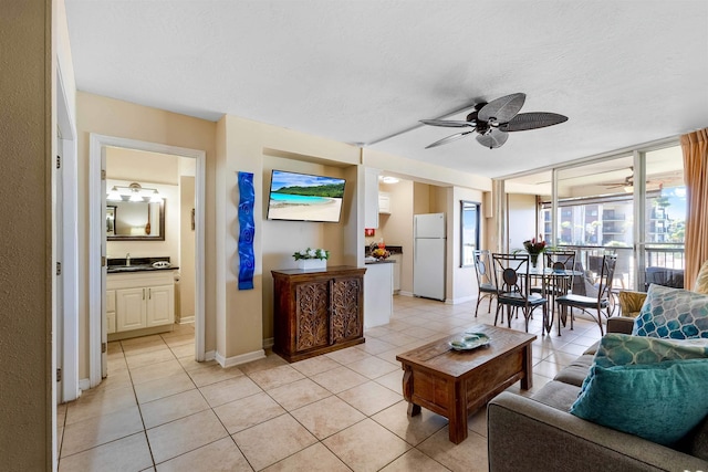 living room featuring light tile patterned floors, a textured ceiling, floor to ceiling windows, and ceiling fan