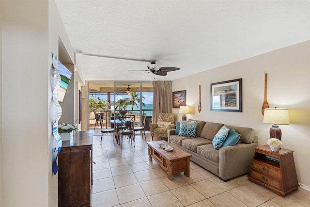 living room featuring light tile patterned flooring, a wall of windows, and ceiling fan