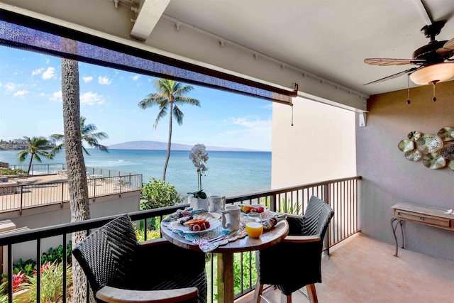 balcony featuring a water view and ceiling fan