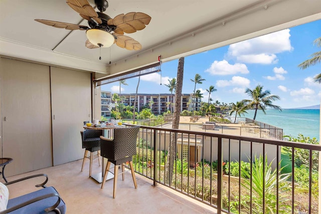 balcony featuring ceiling fan and a water view