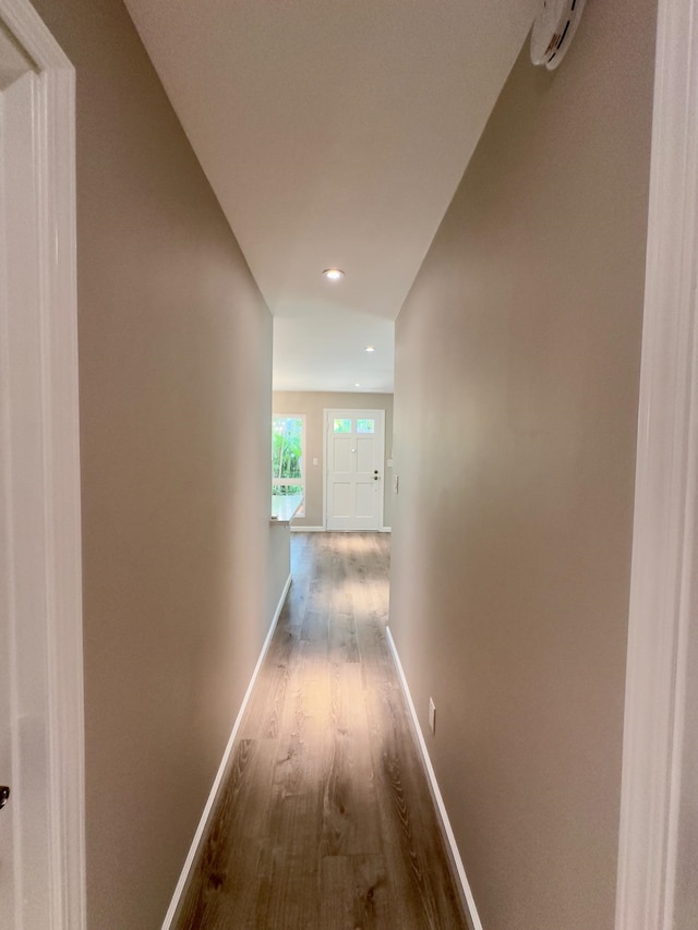 hallway featuring hardwood / wood-style flooring and vaulted ceiling