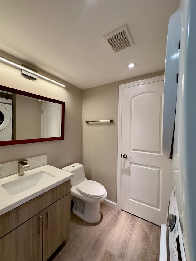 bathroom with wood-type flooring, vanity, and toilet