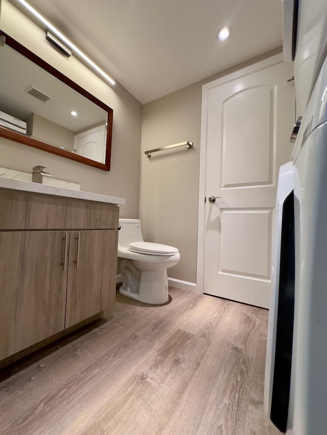 bathroom featuring hardwood / wood-style floors, vanity, and toilet